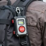 Lone worker safety device clipped to a worker’s bag